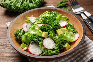 Photo of Delicious salad with kale leaves on table