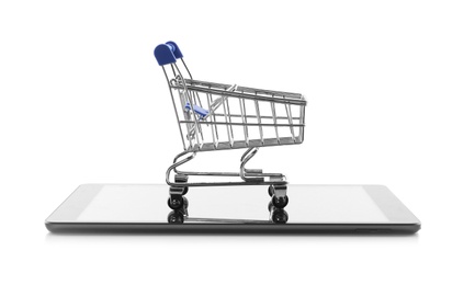 Internet shopping. Small cart and modern tablet on white background
