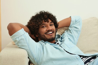 Portrait of handsome smiling man on sofa indoors