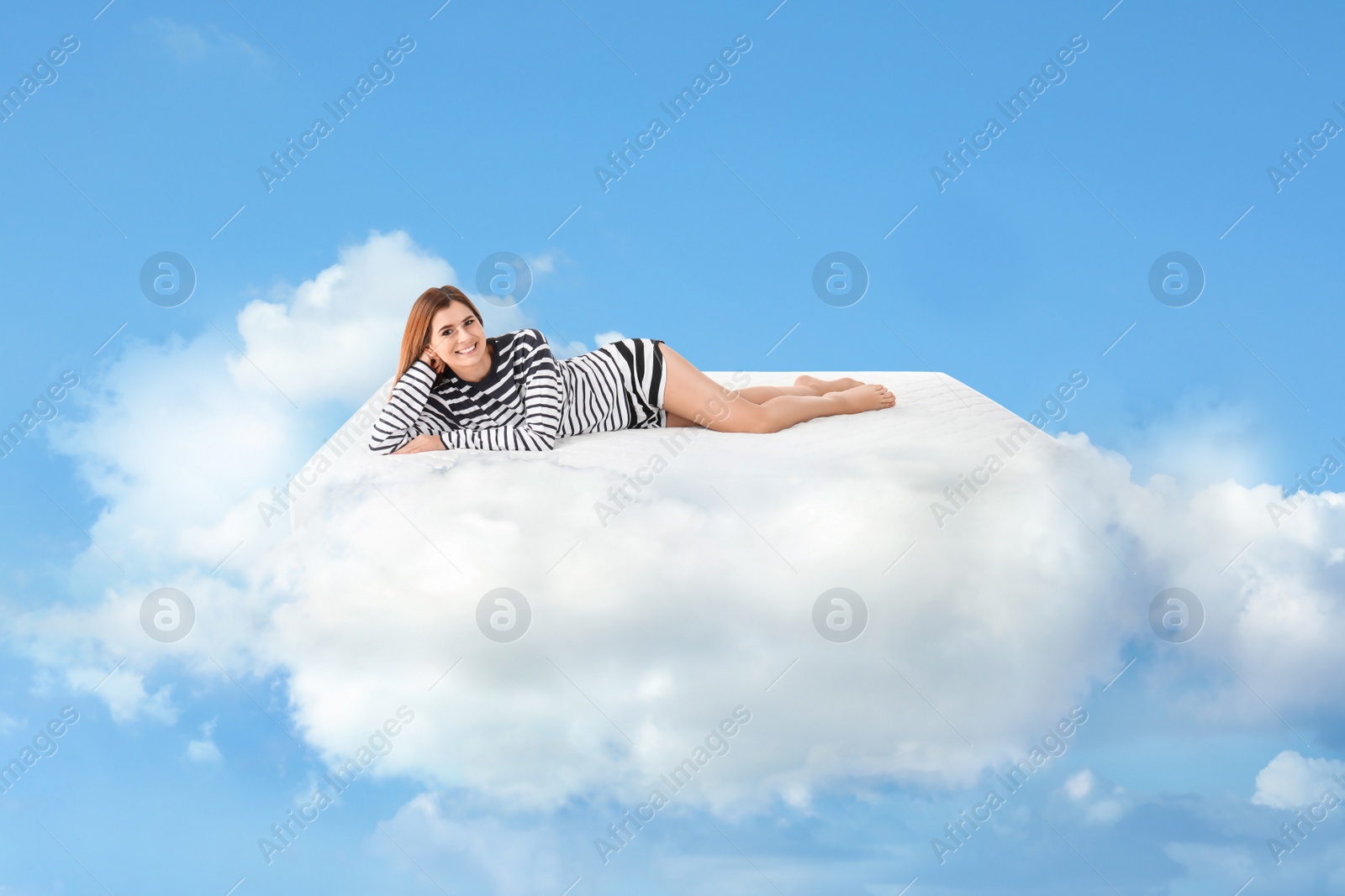 Image of Beautiful woman lying on mattress in clouds