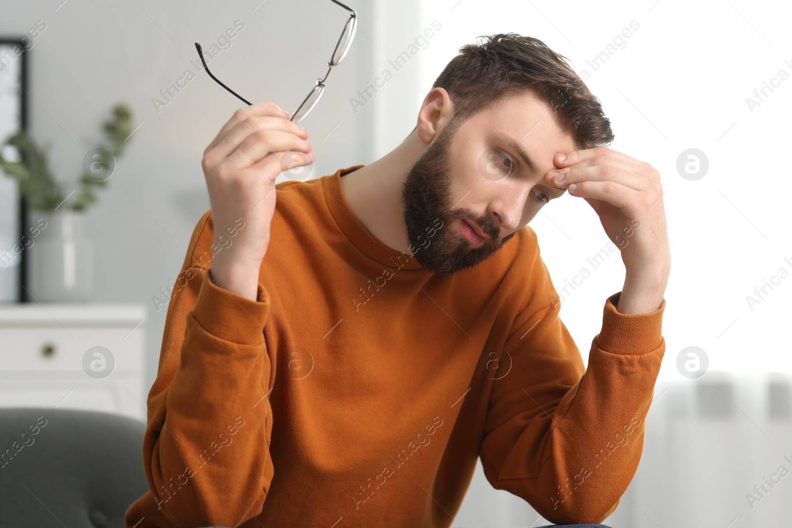 Photo of Overwhelmed man with glasses suffering at home