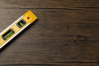 Building level on wooden table, top view. Space for text