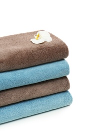 Photo of Stack of clean folded towels with flower on white background