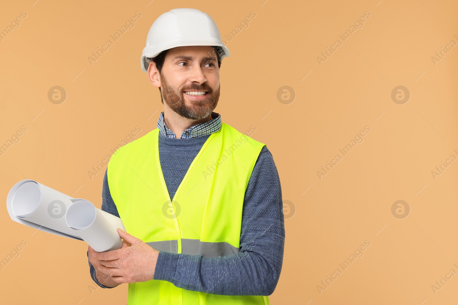 Photo of Architect in hard hat with drafts on beige background, space for text