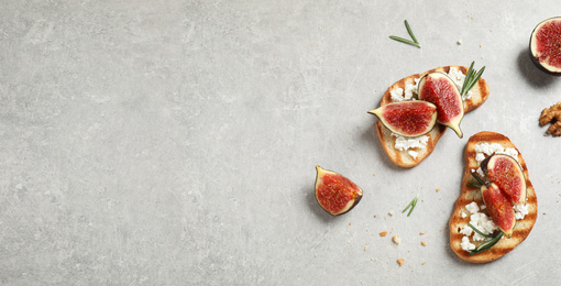 Image of Bruschettas with figs and cheese on light table, flat lay. Space for text, banner design 