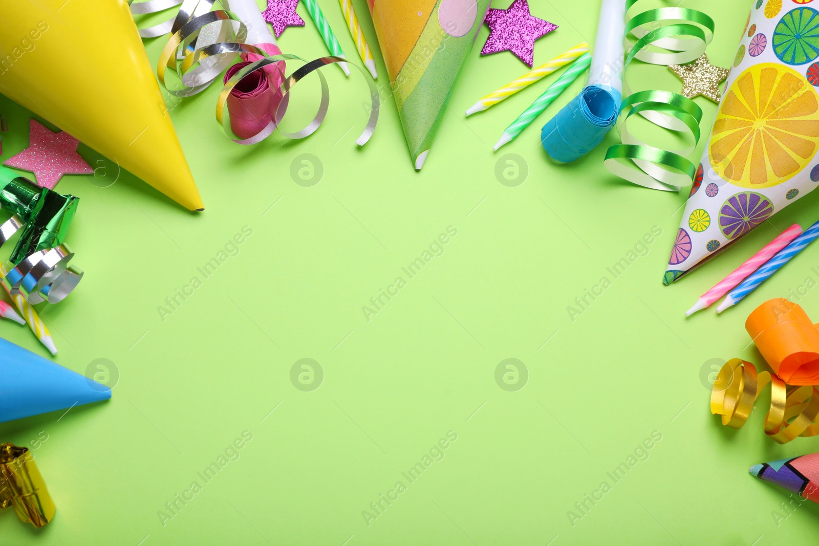 Photo of Different accessories for birthday party on green background, flat lay. Space for text