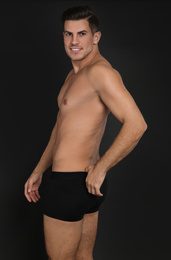 Photo of Handsome man in underwear on black background