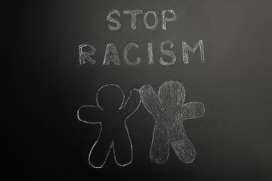 Photo of Chalked inscription Stop Racism and people figures on blackboard