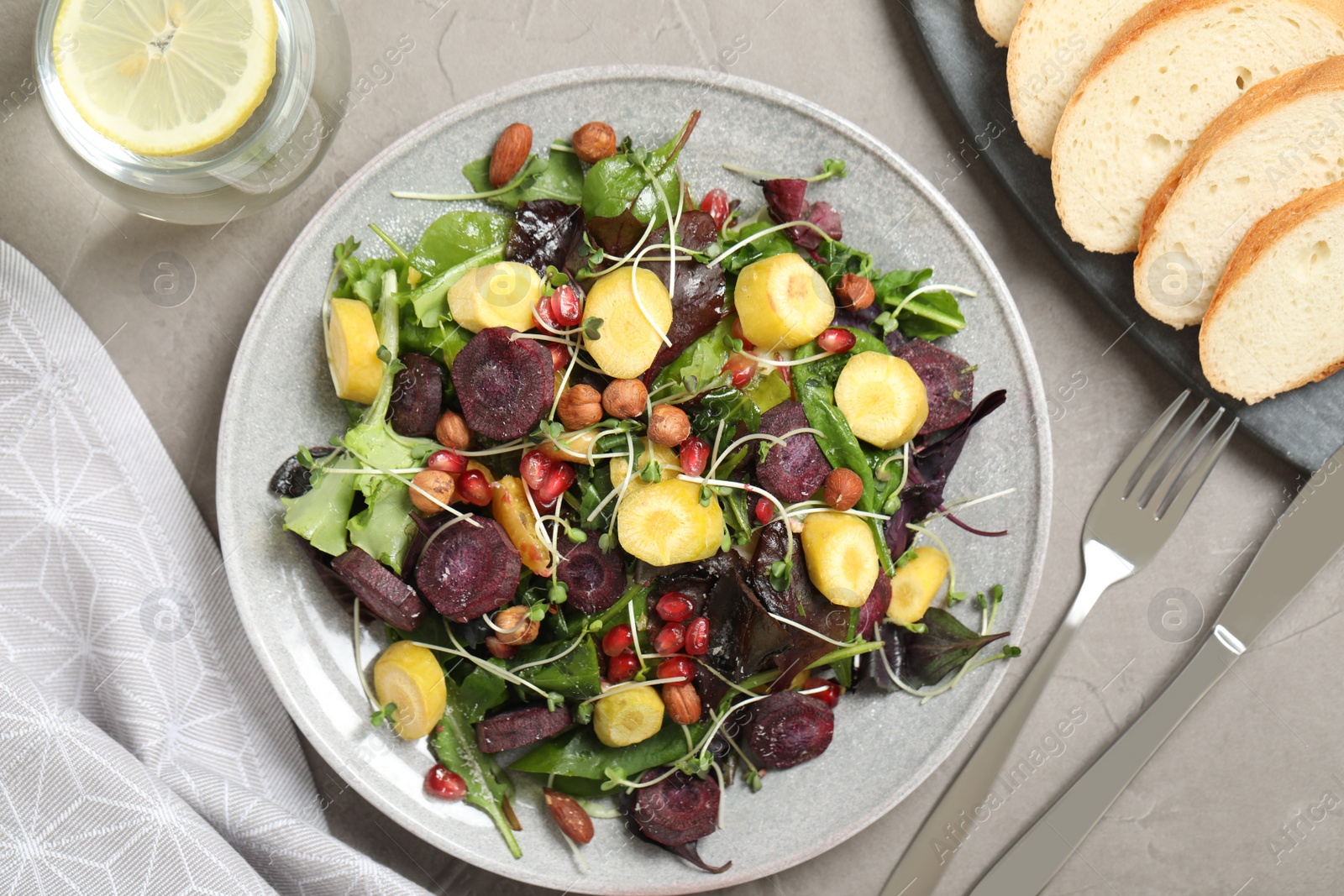 Photo of Delicious fresh carrot salad served on grey table, flat lay