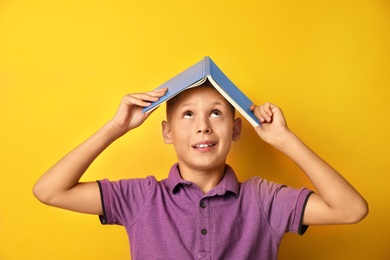 Image of Little boy with book on yellow background