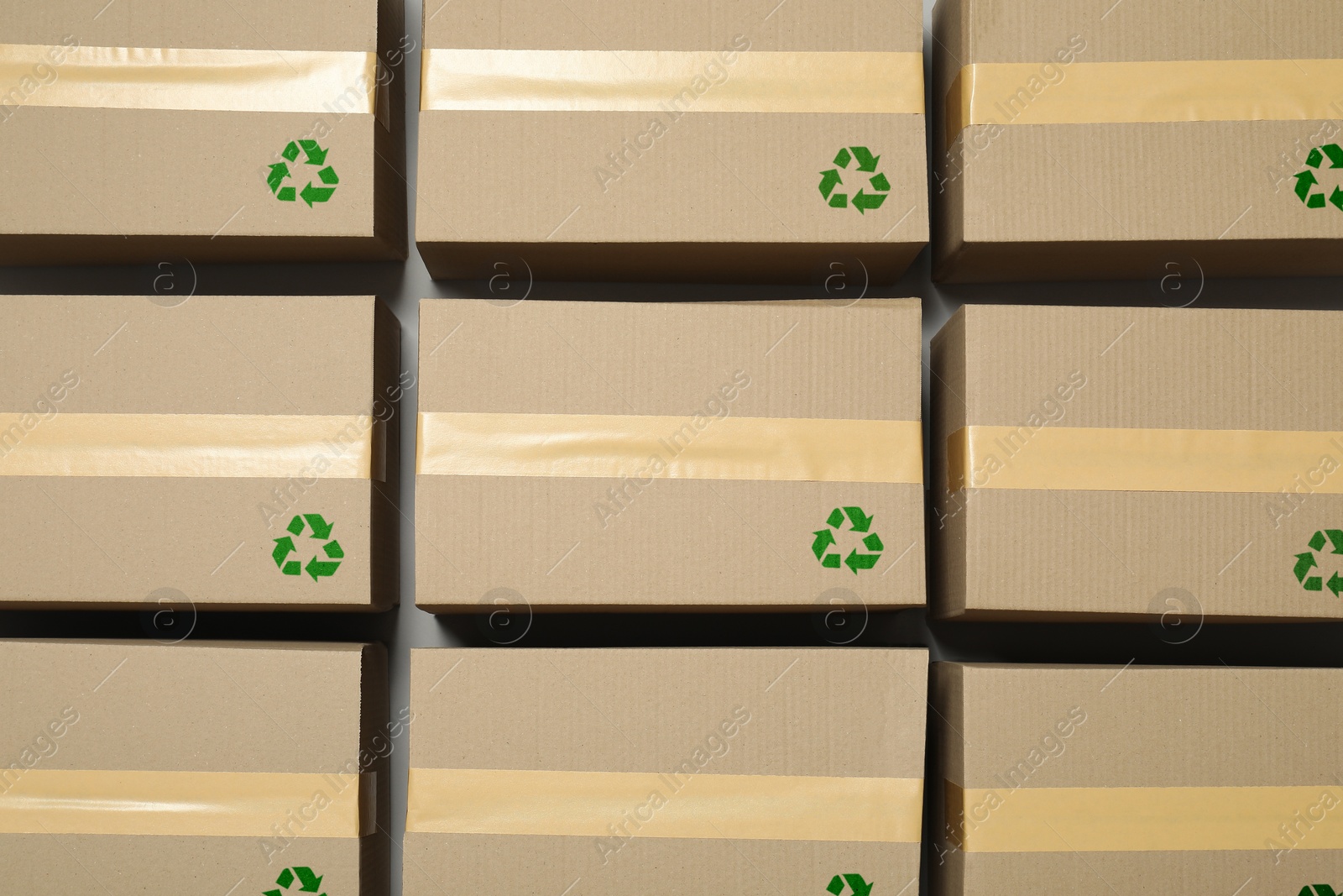 Image of Cardboard boxes with recycle sign stamps on grey background, flat lay