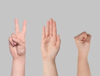 People playing rock, paper and scissors on grey background, closeup