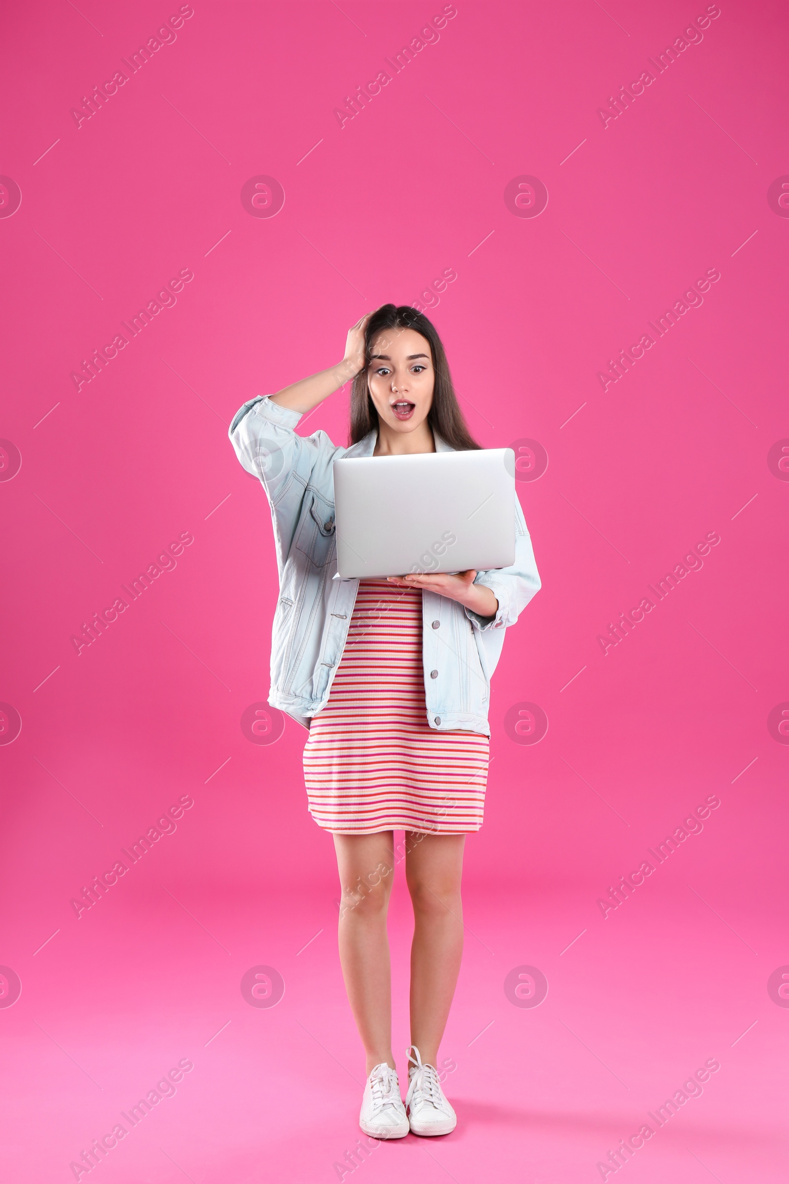 Photo of Full length portrait of shocked young woman in casual outfit with laptop on color background