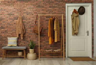 Photo of Hallway interior with stylish furniture, clothes and accessories