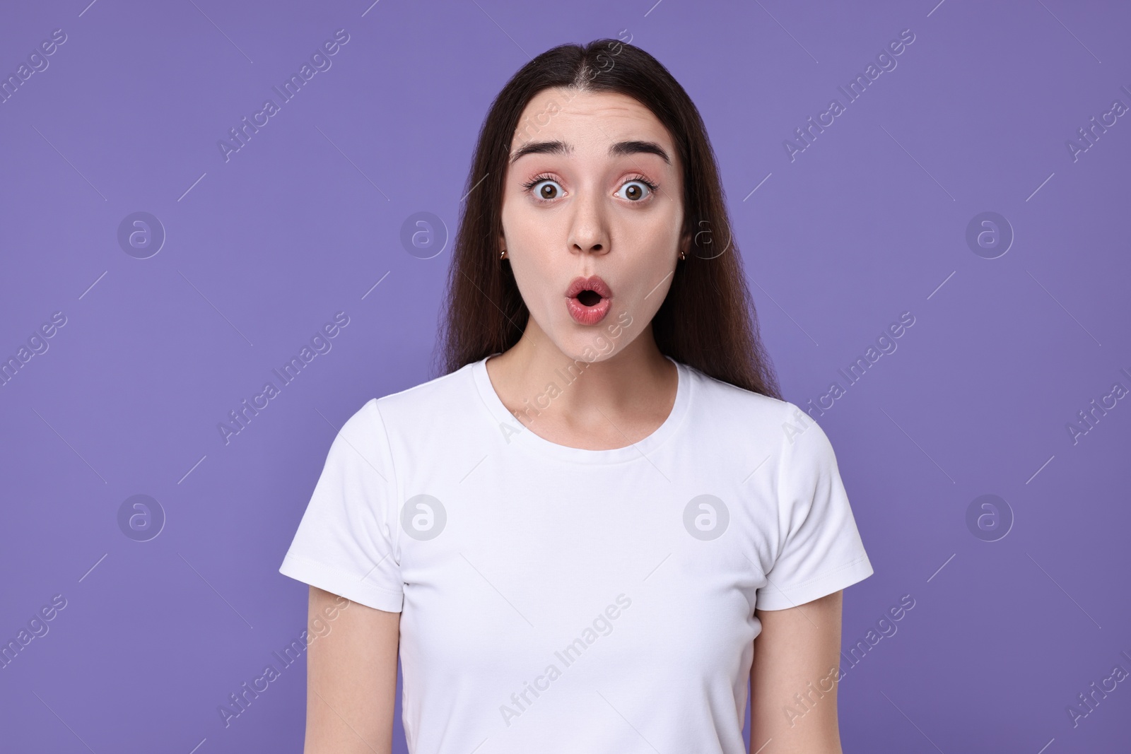 Photo of Portrait of surprised woman on violet background