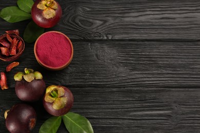 Purple mangosteen powder and fruits on black wooden table, flat lay. Space for text