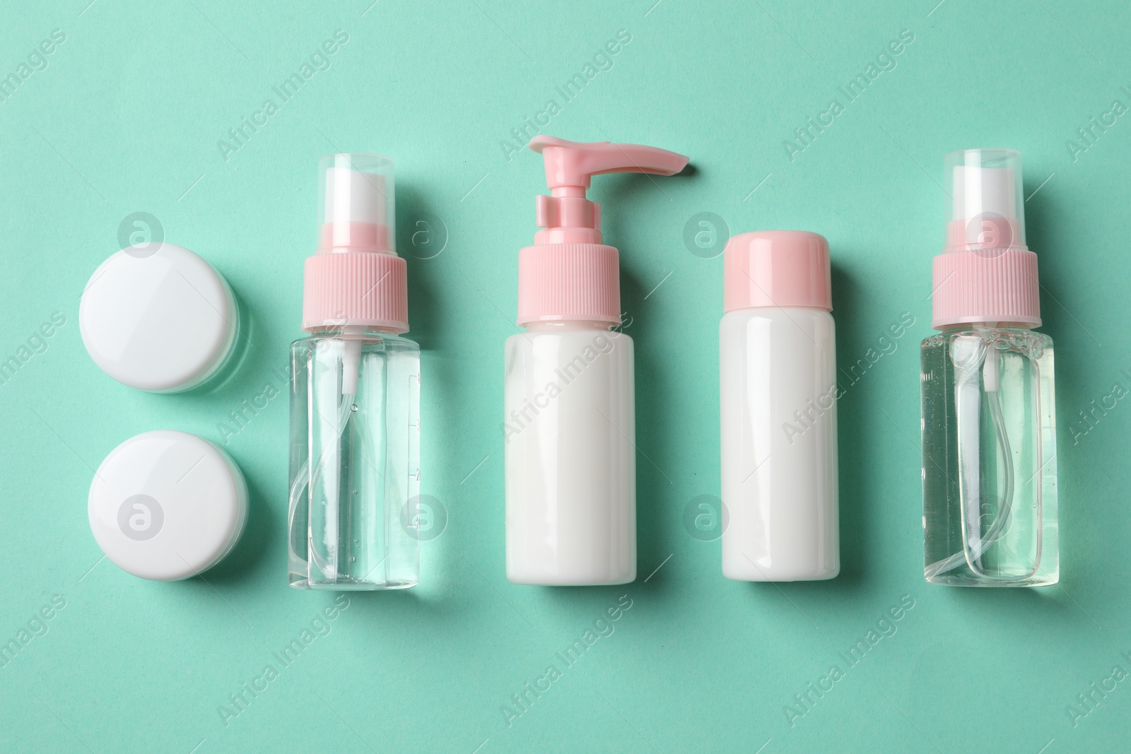 Photo of Cosmetic travel kit on turquoise background, flat lay. Bath accessories