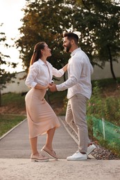 Lovely couple dancing together outdoors at sunset