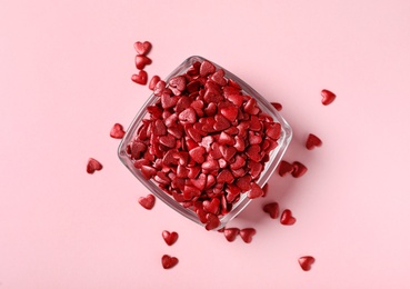 Photo of Red heart shaped sprinkles on pink background, flat lay