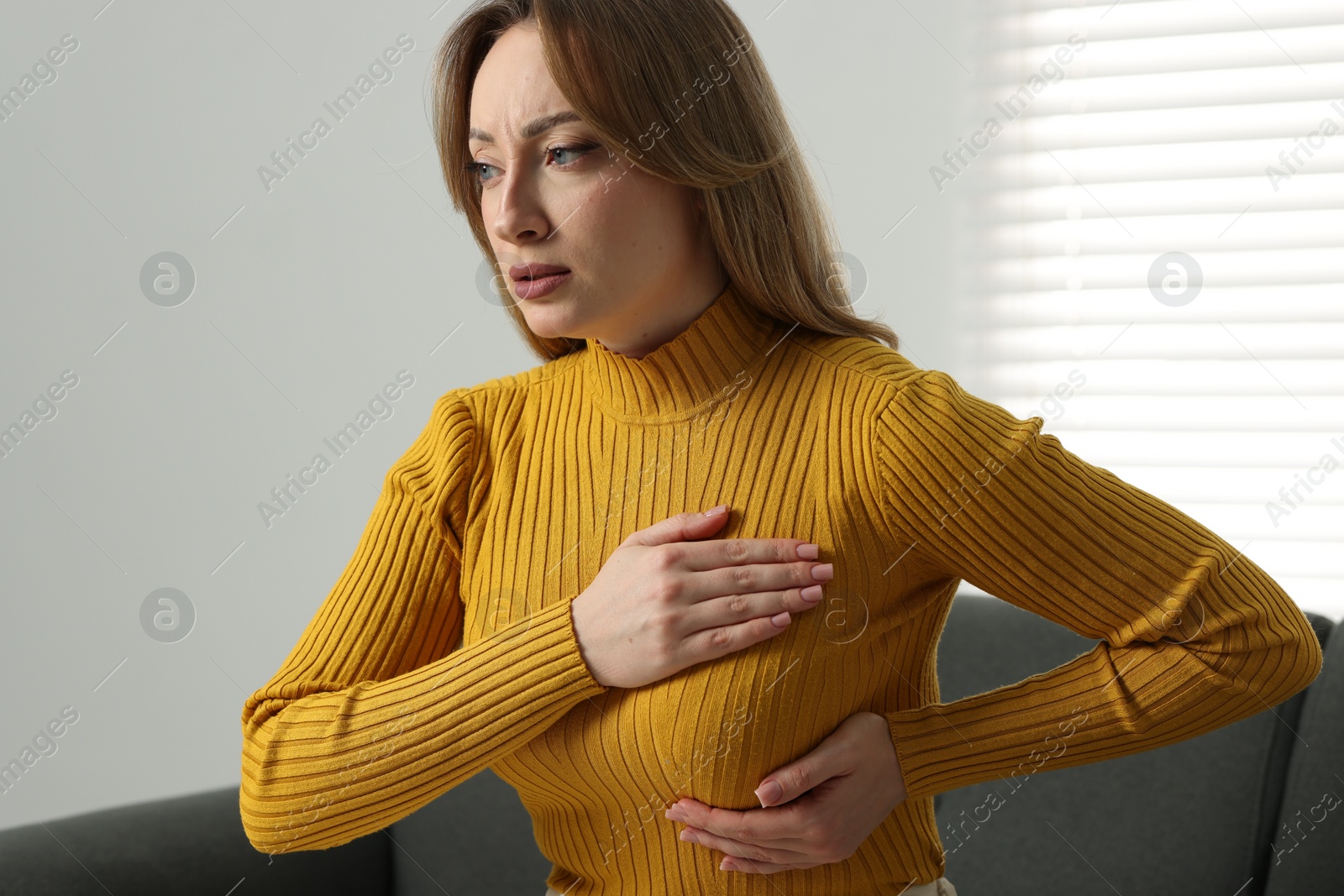 Photo of Mammology. Young woman doing breast self-examination at home