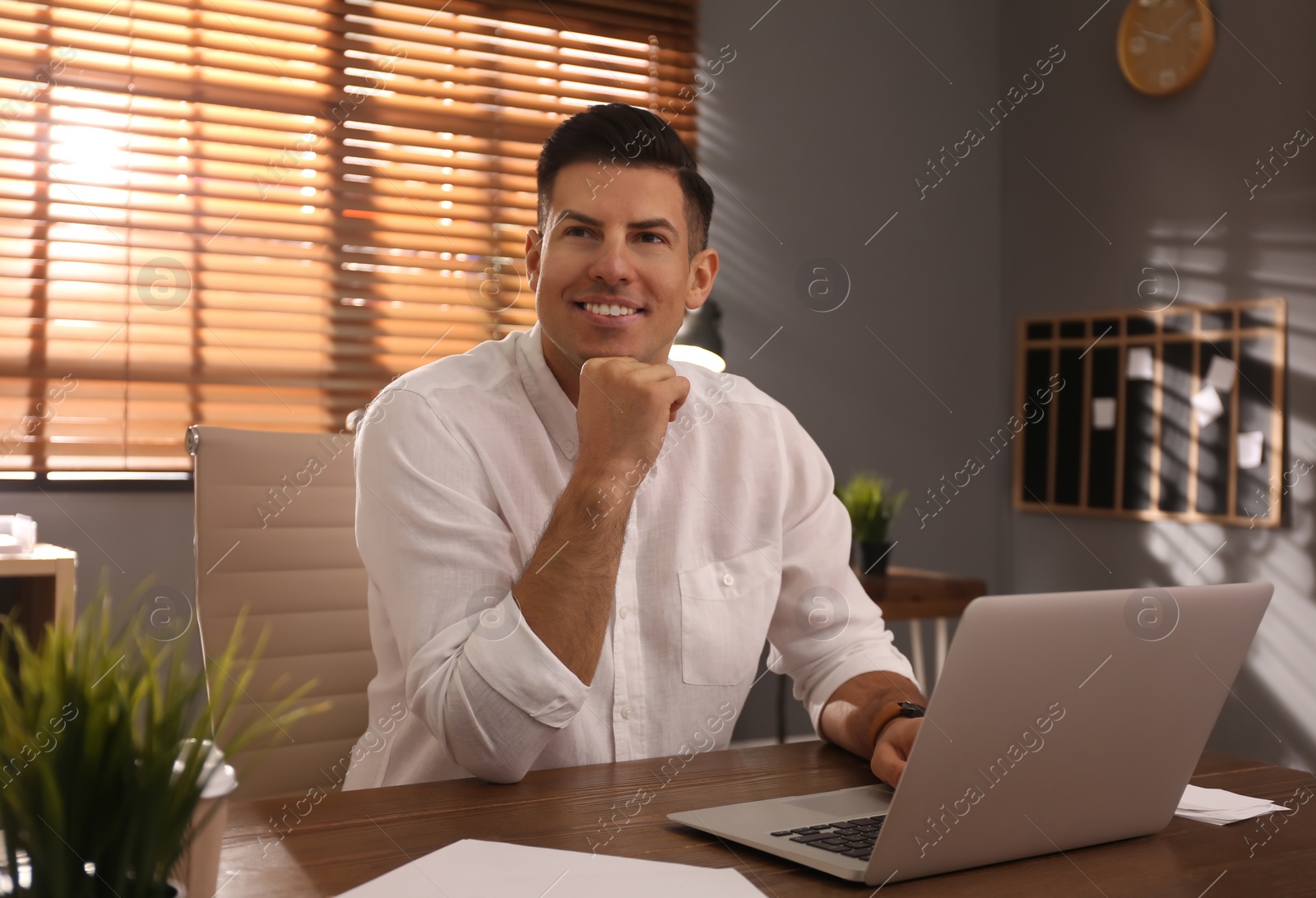 Photo of Freelancer working on laptop at table indoors