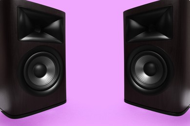 Photo of Wooden sound speakers on violet background. Space for text