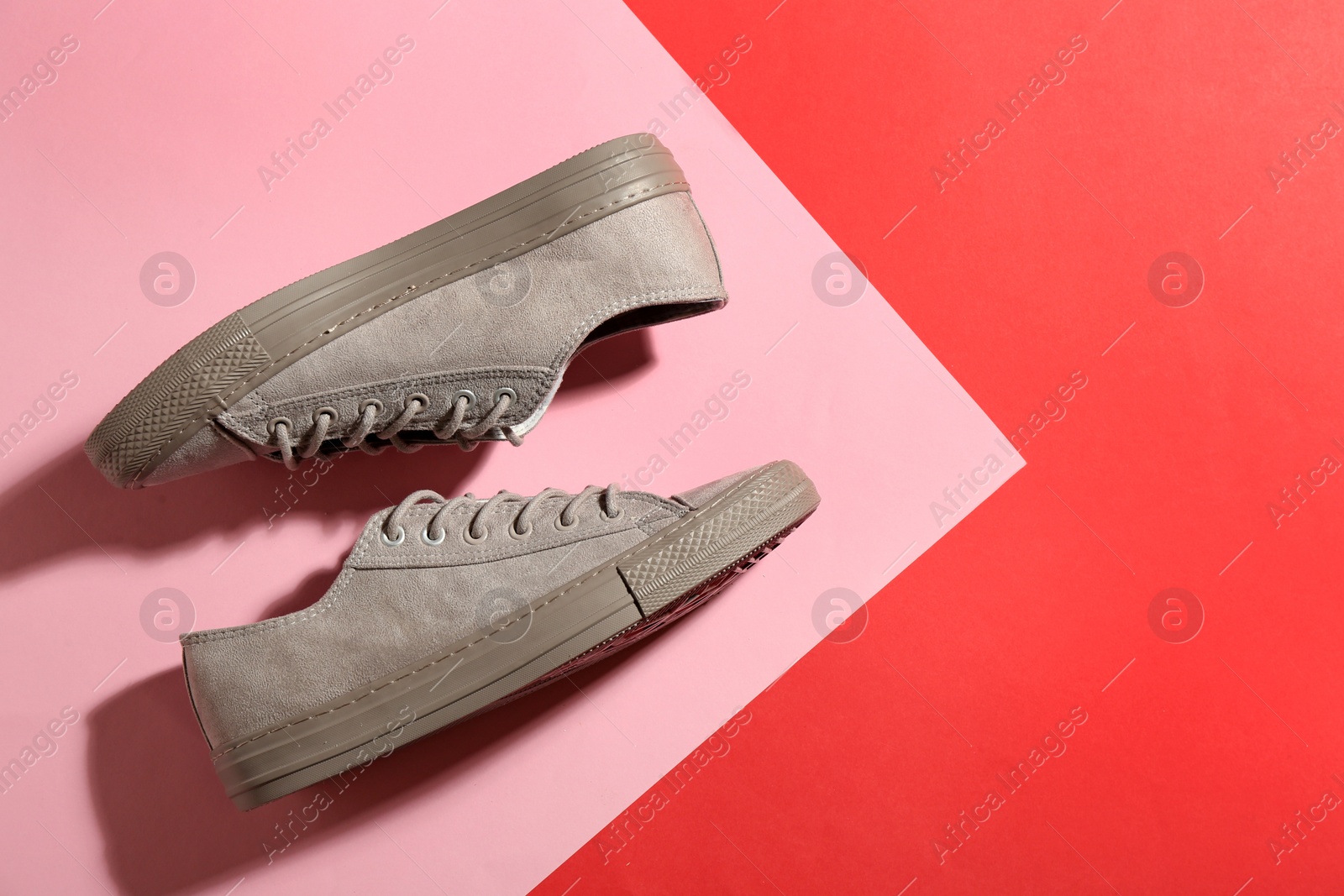 Photo of Pair of stylish sneakers on color background, top view with space for text