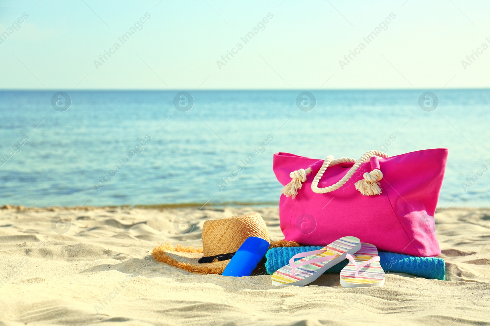 Photo of Composition with stylish beach accessories on sand near sea. Space for text