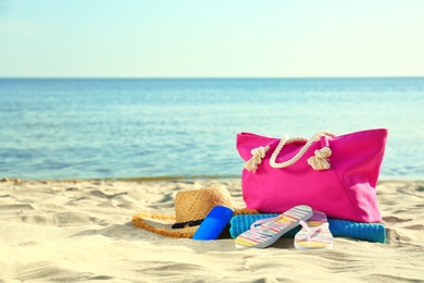 Photo of Composition with stylish beach accessories on sand near sea. Space for text