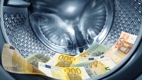 Image of Money laundering. Many euro banknotes in washing machine