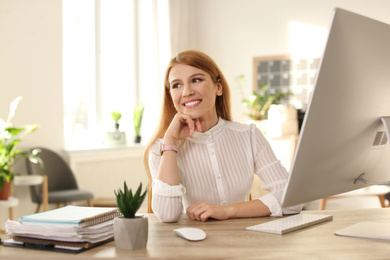 Photo of Young woman relaxing at table in office during break