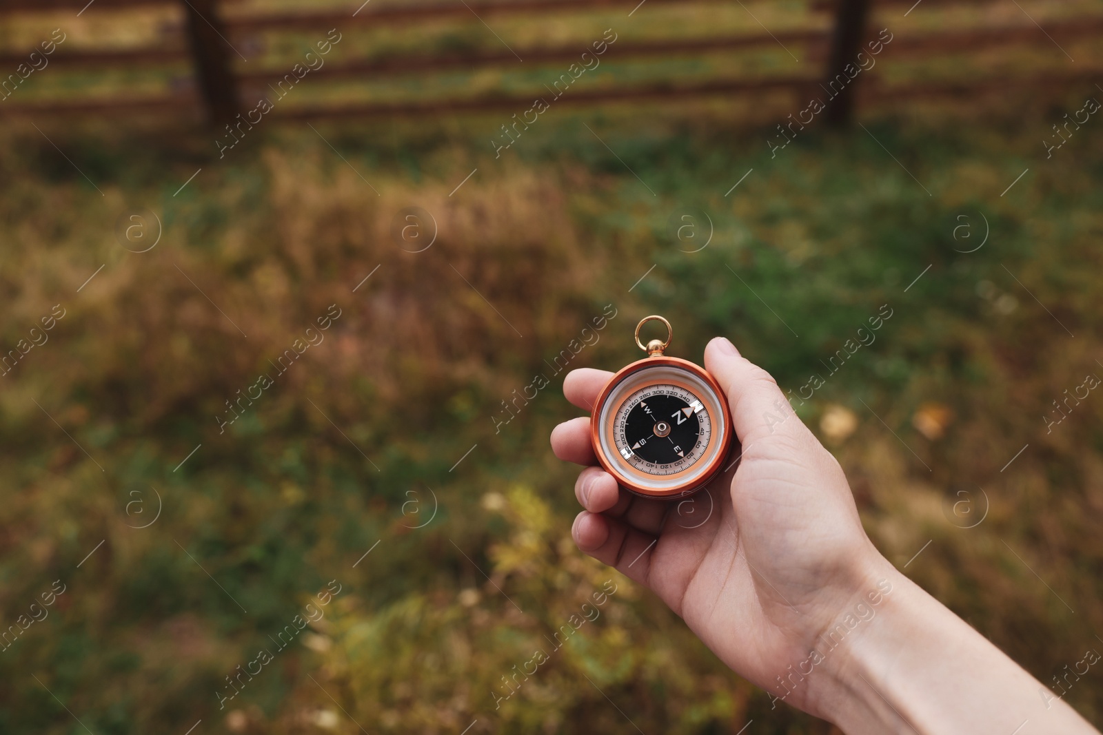Photo of Woman using compass during journey outdoors, closeup. Space for text