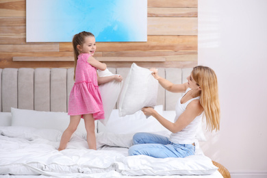 Mother playing with her child in bedroom at home