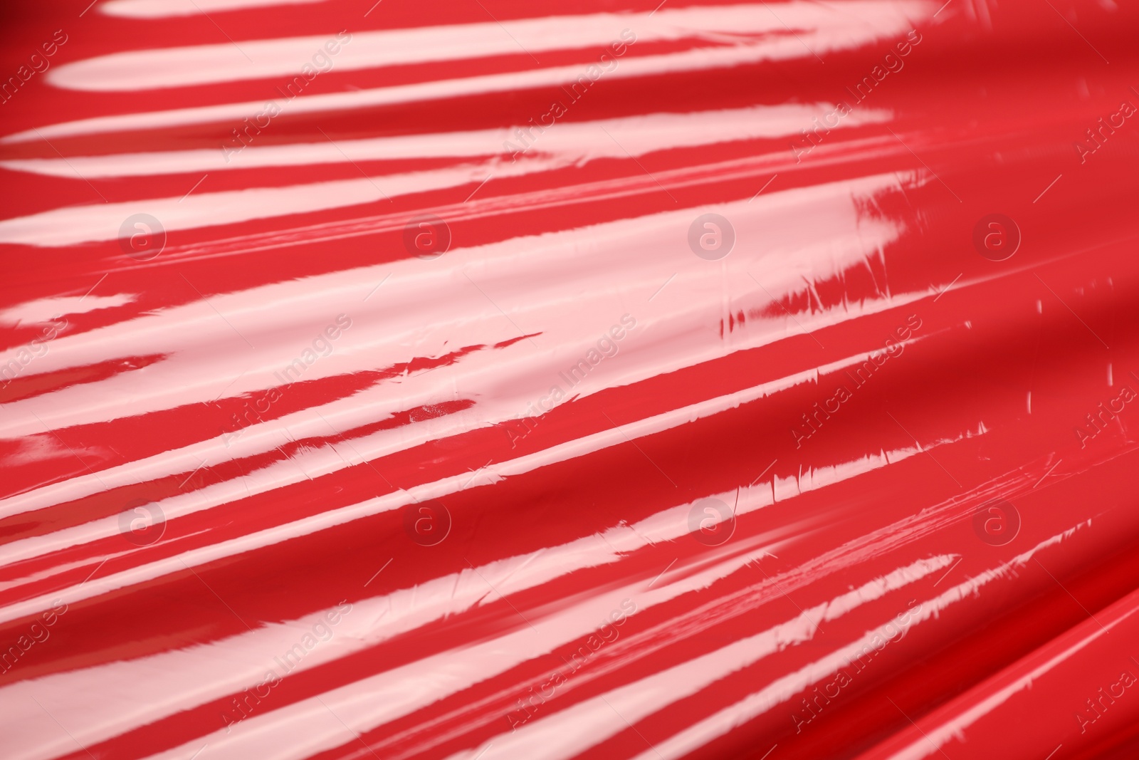 Photo of Red plastic stretch wrap as background, closeup