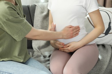 Photo of Doula taking care of pregnant woman indoors, closeup. Preparation for child birth