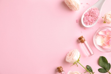 Flat lay composition with rose essential oil on pink background, space for text