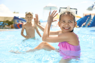 Photo of Little children having fun in swimming pool. Summer vacation