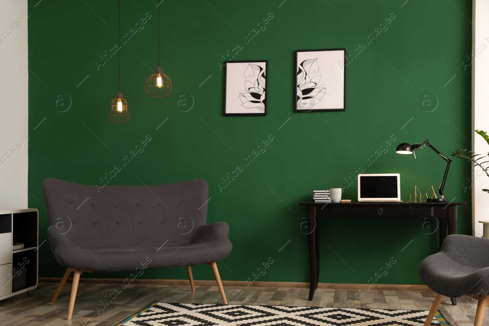 Photo of Modern living room interior with workplace near green wall