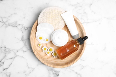 Photo of Set of different cosmetic products and chamomile flowers on white marble table, top view
