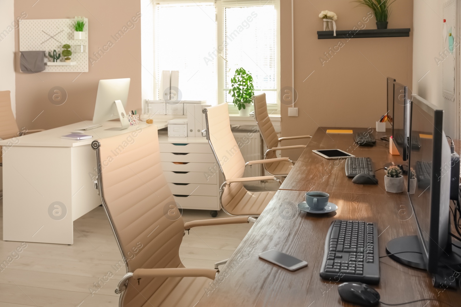 Photo of Stylish workplace interior with computers on tables
