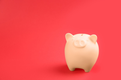 Photo of Beige piggy bank on red background. Space for text