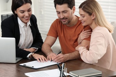 Professional notary helping couple with paperwork in office