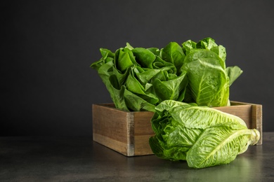 Photo of Wooden crate with fresh ripe cos lettuce on table