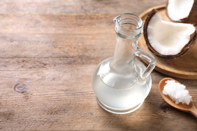 Photo of Coconut oil on wooden table. Space for text