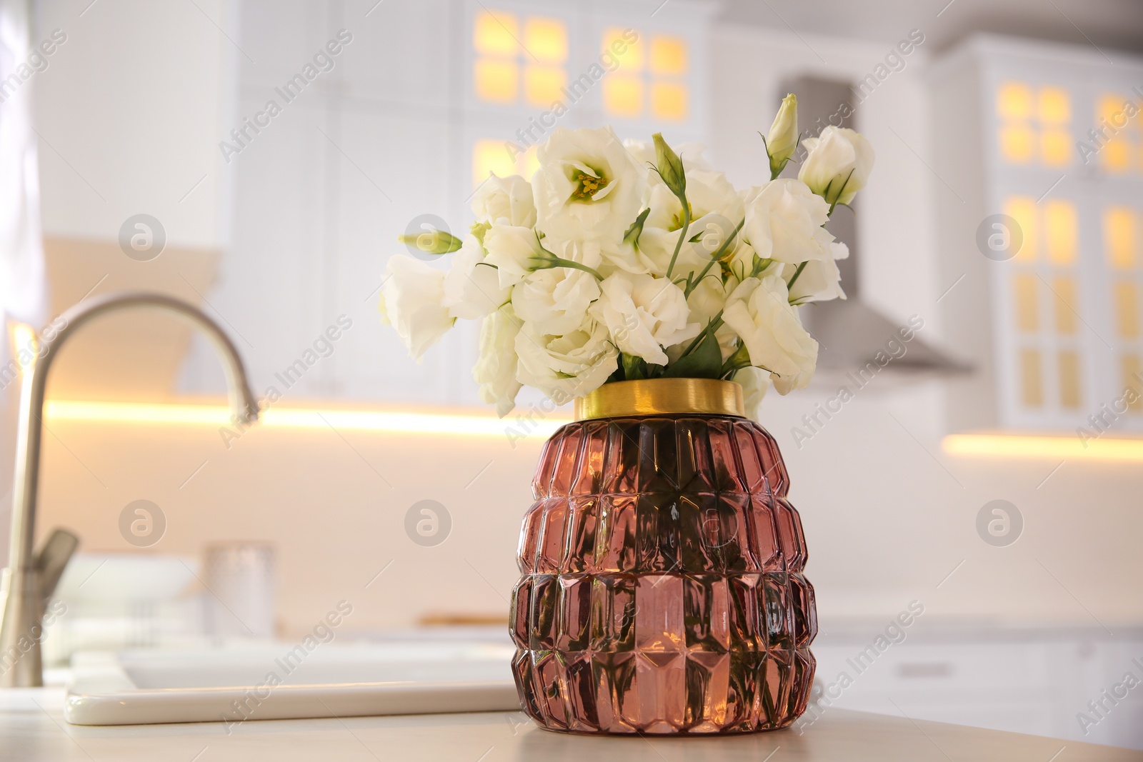 Photo of Bouquet of beautiful flowers on countertop in kitchen, space for text. Interior design