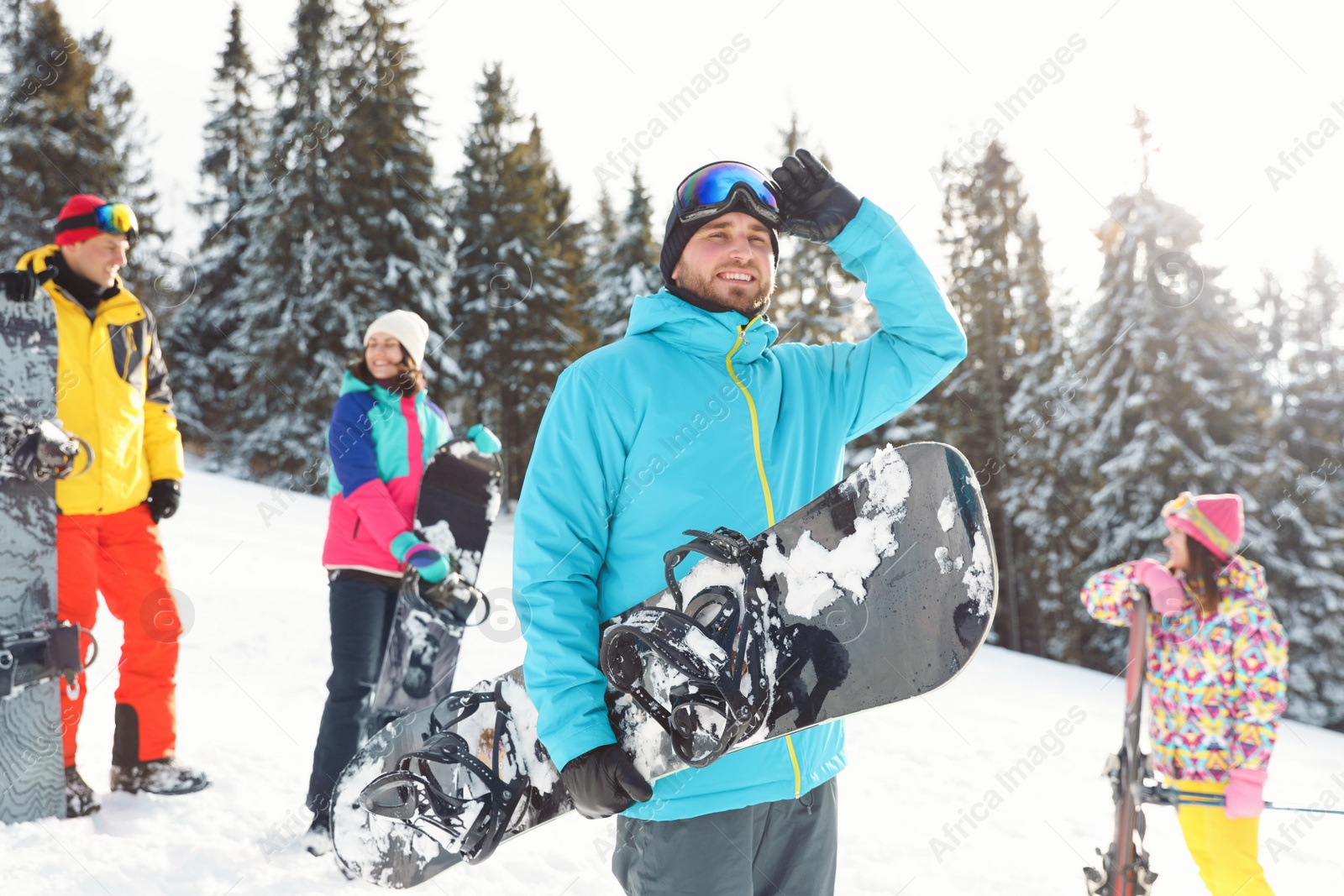 Photo of Young man with friends on snowy slope. Winter vacation