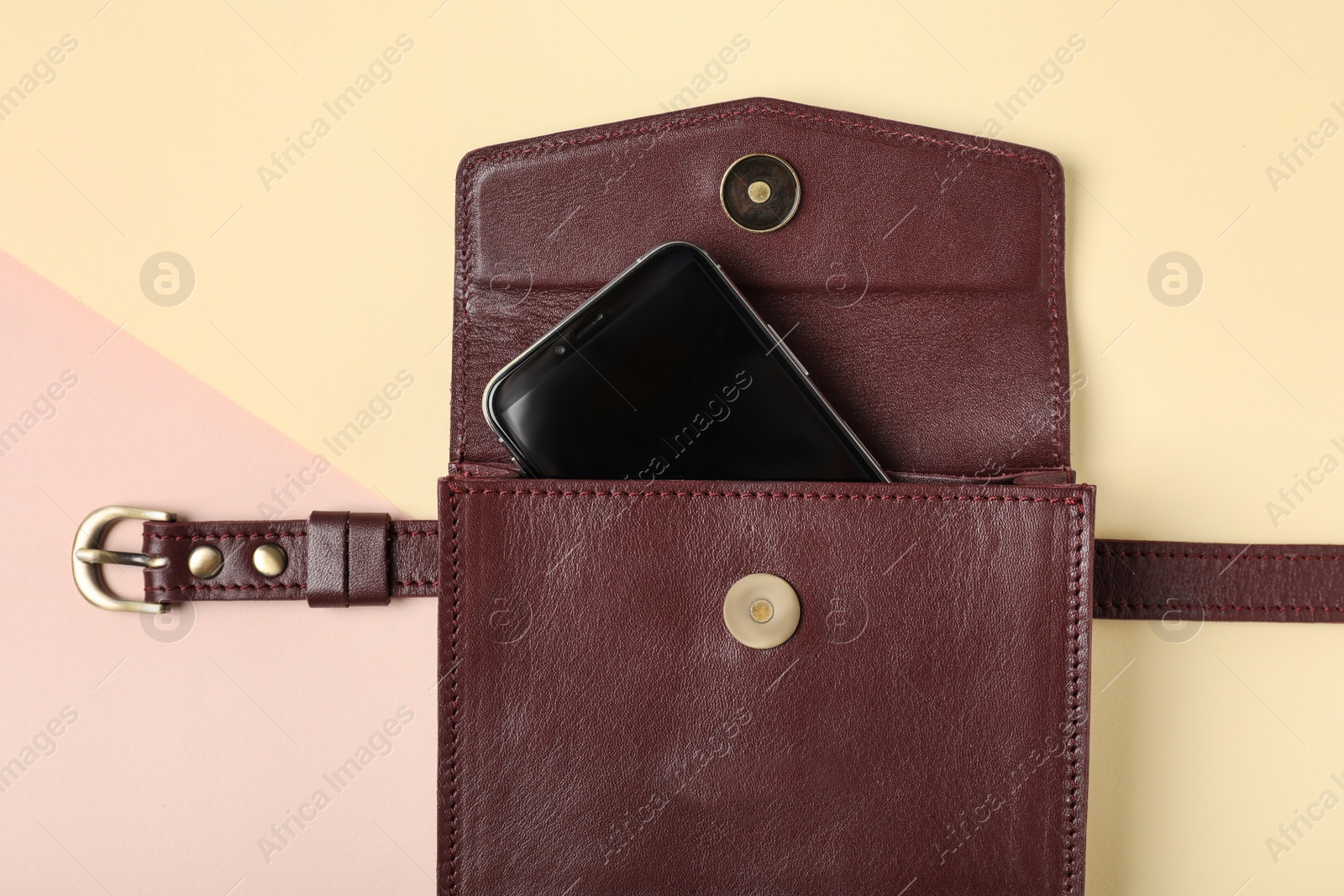 Photo of Stylish women's bag with smartphone on color background, top view