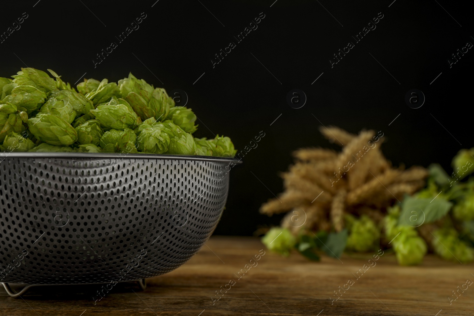 Photo of Fresh green hops on wooden table, closeup. Space for text