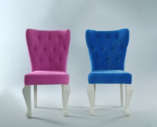 Stylish chairs on light grey background. Element of interior design