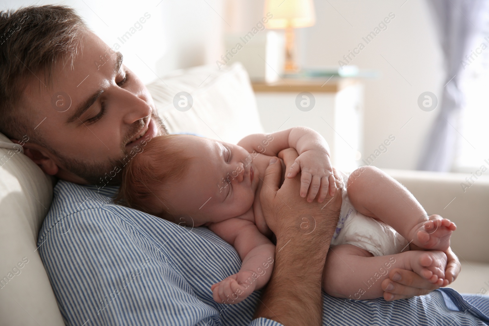 Photo of Father with his newborn son at home